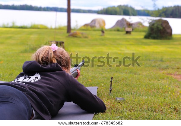 A young\
girl shooting an air rifle at a\
target.