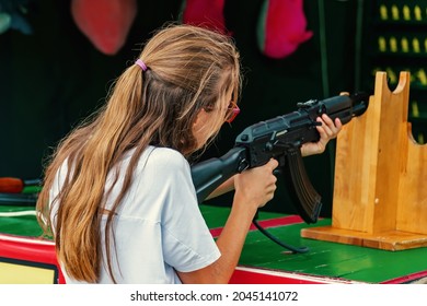 A young girl shoots from a machine gun at a shooting range. 