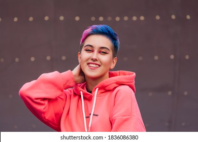 Young Girl With Short Colorful Hair And Nose Piercing Dressed In Pink Hoodie