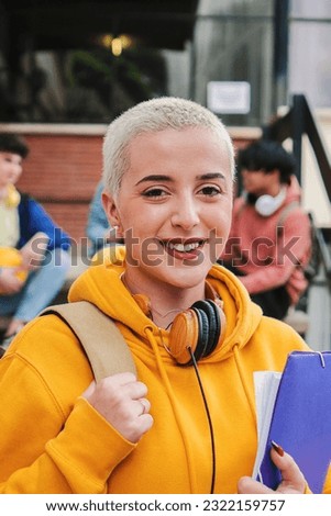 Young girl with short hair student looking at camera in campus - High Quality Photo