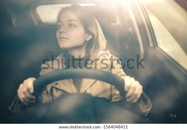 young girl with a short haircut driving and holds the\
steering w