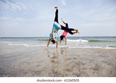 Young girl show an acrobatic on the beach.