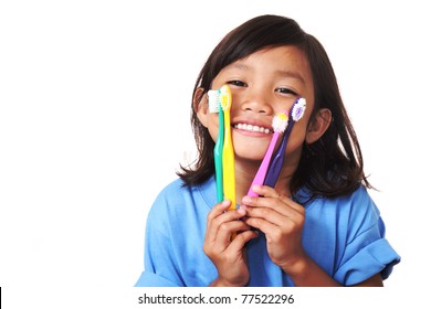 Young girl showing toothbrush and her white teeth