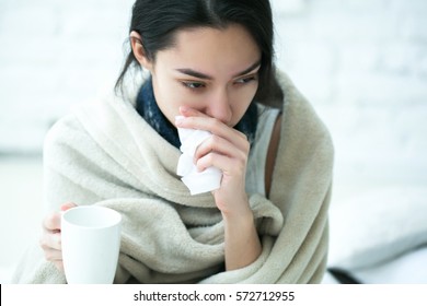 Young girl sick in bed with temperature drinks hot  - Shutterstock ID 572712955