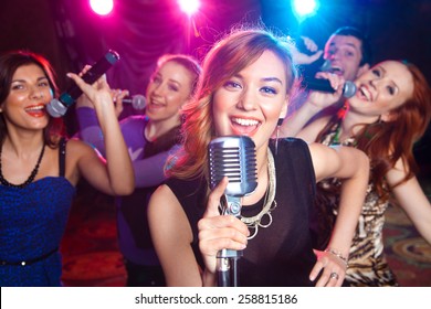 Young girl singing into  microphone at  party - Powered by Shutterstock