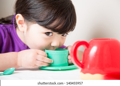 Young girl sipping from her cup having a tea party - Powered by Shutterstock