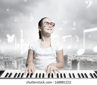 Young girl sitiing at digital piano with red glasses