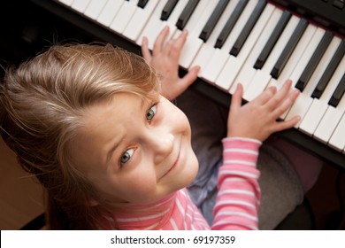 Young girl sitiing at digital  piano