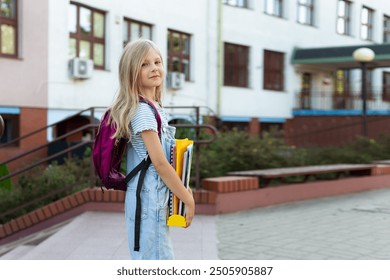 A young girl sits alone in the schoolyard, face in hands, showing sadness and stress - Powered by Shutterstock