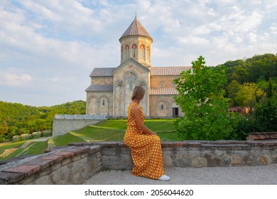 a young girl sits on the parapet of a monastery in sighnaghi