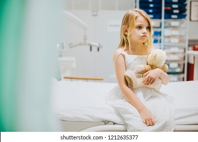 Young girl sitting alone on a hospital bed - Powered by Shutterstock