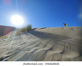 Young Girl Sledding On Sand Dune