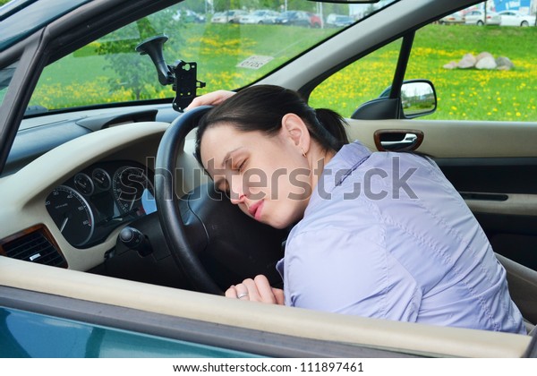 Young girl sleeps in her
car.