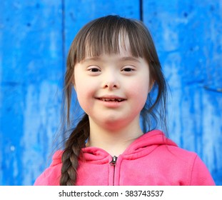 Young girl smiling on background of the blue wall