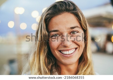 Young girl smiling on camera with beach bar on background - Soft focus on eyes
