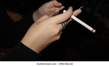 Young Girl Smoking and Looking at Her Cell Phone