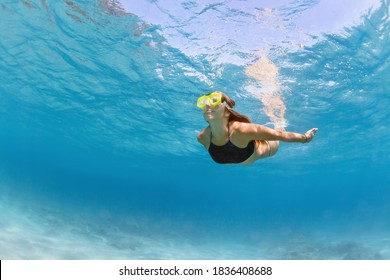 Young Girl In Snorkeling Mask Dive In Coral Reef Sea Lagoon To Explore Underwater World. Family Travel Lifestyle In Summer Adventure Camp. Swimming Activities On Beach Vacation With Kids.