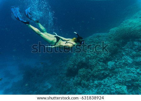 Young girl at snorkeling in the tropical water.