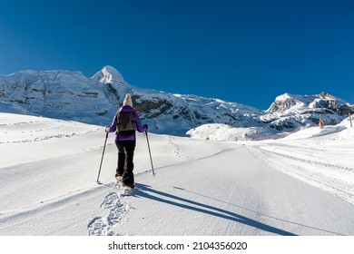 A Young Girl With Snow Rackets, Walks Through A Completely Snowy Landscape In The Pyrenees Mountain Range (Spain).