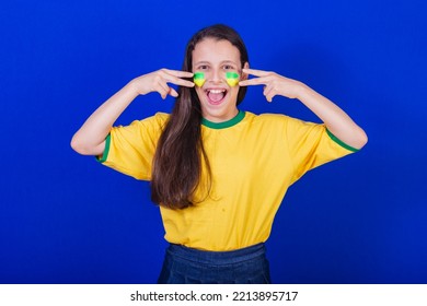 Young Girl, Soccer Fan From Brazil. Putting Paint On Your Face.