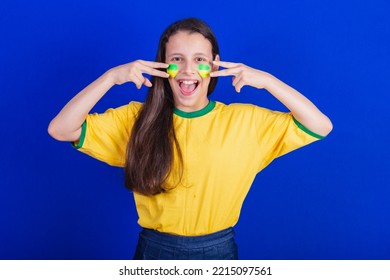 Young Girl, Soccer Fan From Brazil. Putting Paint On Your Face.