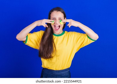 Young Girl, Soccer Fan From Brazil. Putting Paint On Your Face.