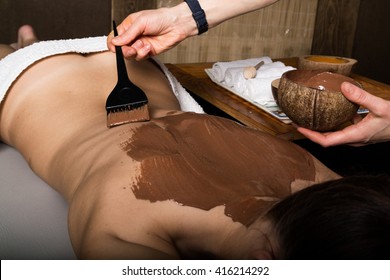 Young Girl In The Spa Salon, Chocolate Body Wrap Treatment, Skin Rejuvenation. Beauty Treatment Concept