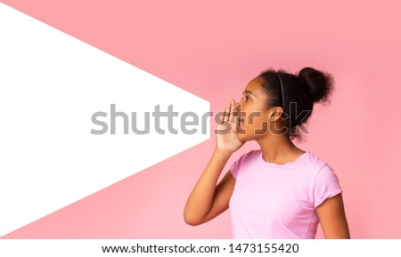 Young girl speaking loud aside to imaginary amplifier holding hand near her open mouth. Side view with empty space