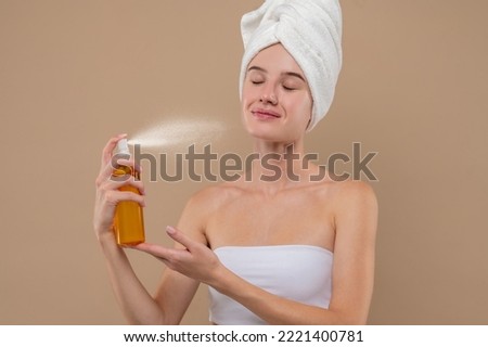 Young girl spraying hydrating mist on her face