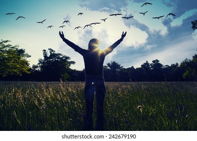 Young girl spreading hands with joy and inspiration facing the sun,sun greeting,freedom concept,bird flying above sign of freedom and liberty