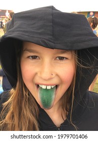 Young Girl Sticking Green Blue Tongue Out Wearing Fake Jewel Nose Stud And Black Hoodie