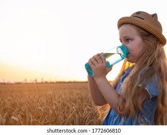 Young Girl In Straw Hat Holds Reusable Bottle In Hands And Drinks Water In Wheat Field. Pure Mineral Water Advertisement. Active Lifestyle Body Care. Rehydration Of Kids Body Hot Weather,liquid Assets