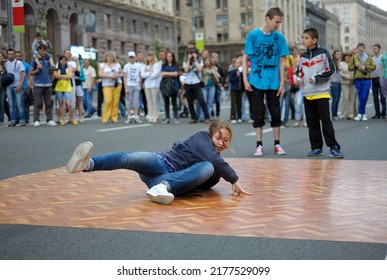 Young Girl, Street Dancer, Performimg Break Dance On The Pavement, Crowd Of People Watching On A Background. May 19, 2019. Kyiv, Ukraine