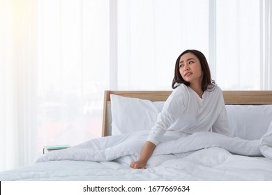 寝室でベッドで起き上がる美しい女性は 伸び伸びして微笑んでいる の写真素材 今すぐ編集