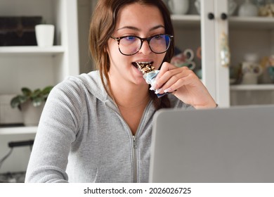Young Girl Student Biting Healthy Snack Granola Bar While Using Laptop Computer