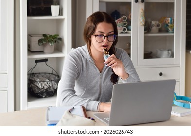 Young Girl Student Eating Healthy Snack While Using Laptop Computer