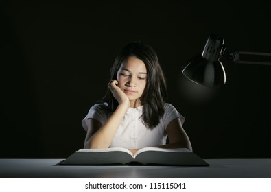 Young Girl Student, Studying Late Into The Night With Her Book And Homework