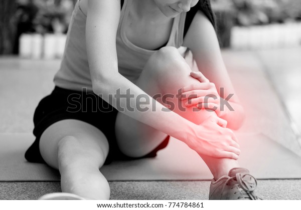 Young girl suffering or injury leg after do yoga. \
russian woman or student has pain in his foot or shin while\
exercise or warm up. sport woman runner hurting holding painful\
sprained  ankle in pain