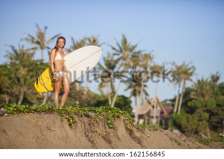 young girl with surfboard at  beach