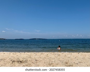 A Young Girl Swimming In The Calm Ocean Waters Of Noyack Bay In Sag Harbor. Long Beach Or Foster Memorial Beach Has White Sand, A Calm Surf, And A Beautiful View Of Greenport And Shelter Island.