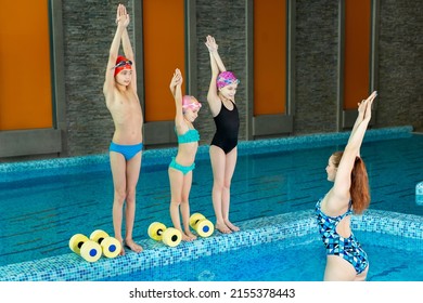 A young girl swimming coach teaches young children to swim. - Powered by Shutterstock