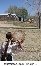 A Young Girl Takes Careful Aim At A Log Target At Which She's About To Launch A Throwing Tomahawk