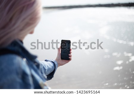 young girl taking selfie on the beach