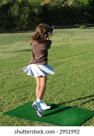 Young Girl Taking A Shot During A Golf Lesson