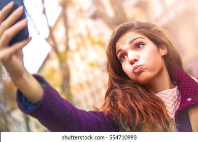 Young Girl Taking A Silly Selfie On The Go 