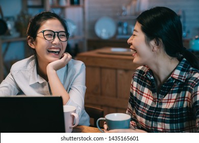 Young Girl Talking Chatting With Best Friend While Working On Laptop Computer. Woman Stay Up Late Doing Project With Roommate Care Be With Her. Two Laughing Cheerful Female In Night Home Kitchen.