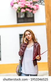 Young Girl Talking On Her Smartphone While Studying Abroad In Seville Spain