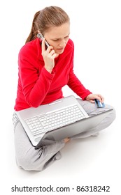 Young Girl Talking On The Phone With Laptop In Her Lap And Holding Credit Card With Other Hand