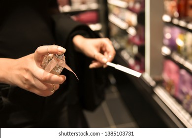 a young girl is testing a sensual perfume, scent  fragrance. Business woman spray  the perfume in the shop, store. 