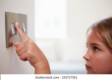 Young Girl Turning Off Light Switch